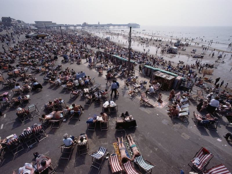 Crowds of holidaymakers relax in the summer sun by the seafront in the seaside resort of Blackpool, Lancashire, August 1983