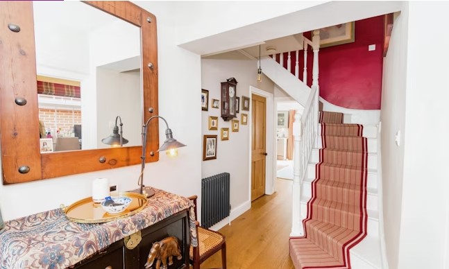 The listing says: "From the welcoming entrance hall (with storage cupboard) is a stylish sitting room with a lovely bay window and fireplace."