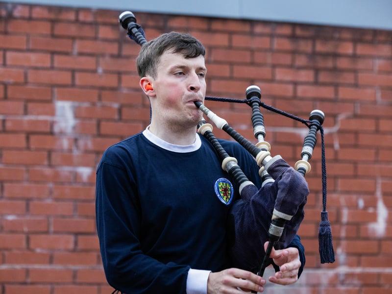 A bagpiper plays outside of Hampden in a retro Scotland jersey.