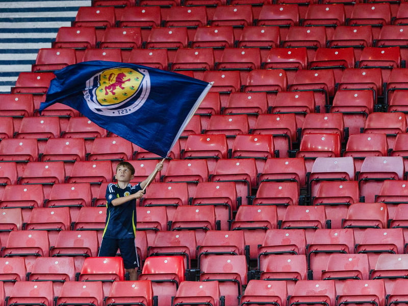 A young fan waves his giant Scotland flag.