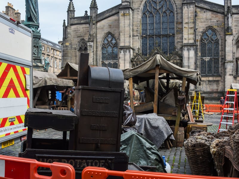The set is being decorated with period items such as the cart.
