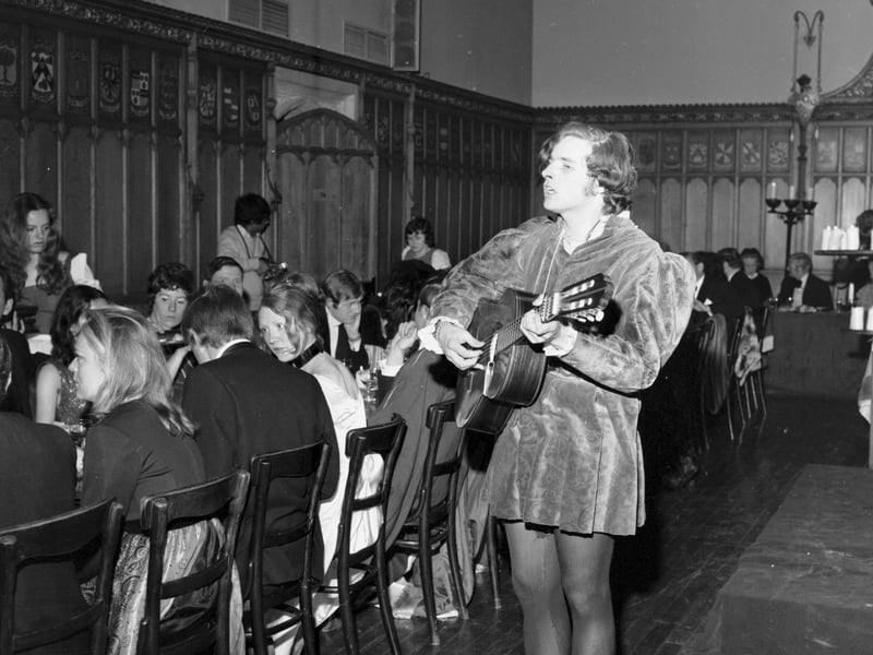 A minstrel plays while guests tuck in at a medieval banquet held by Edinburgh University students at the Assembly Hall in April 1971 .