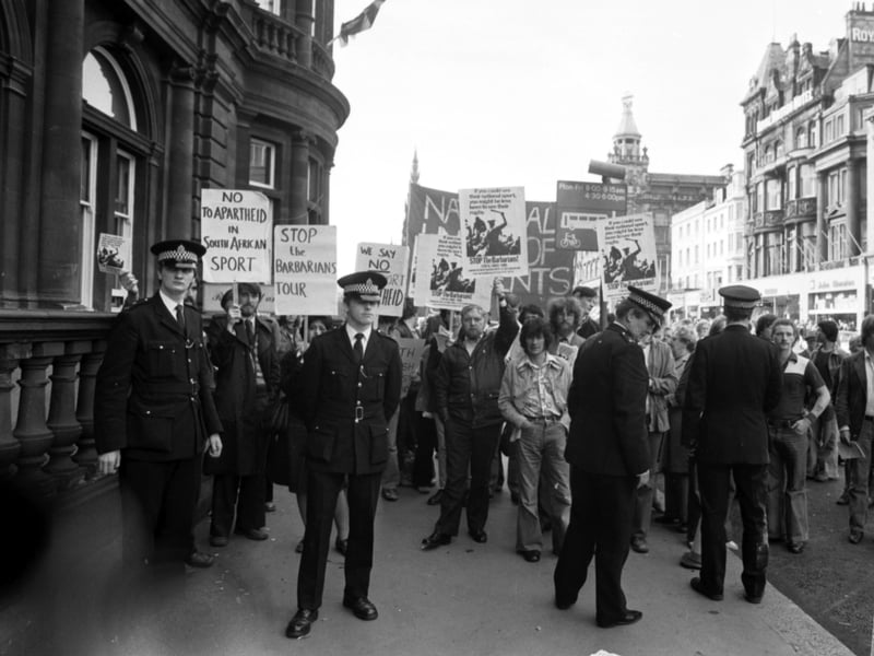 Police keep an eye on anti-apartheid demonstrators protesting as South Africa's Barbarians rugby team arrive at the North British hotel in Edinburgh, October 1979.