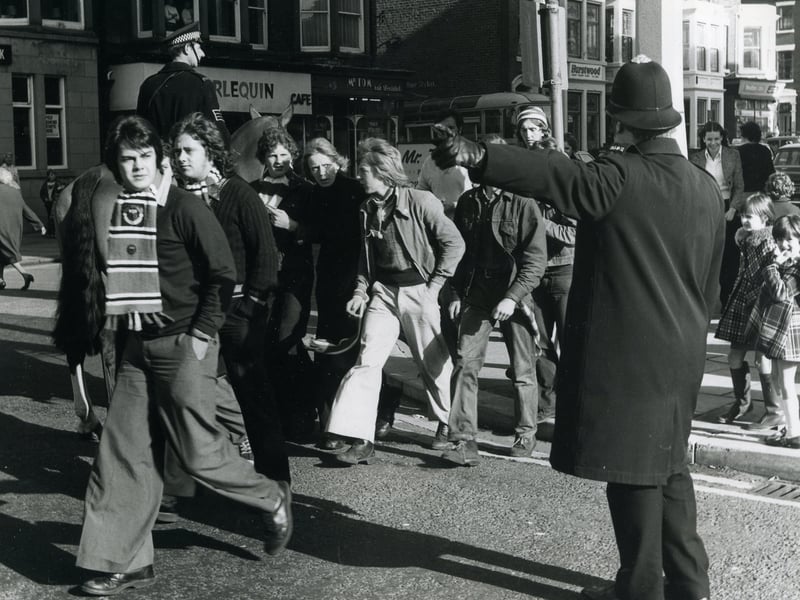 Police escorting Manchester United Supporters through the streets of Blackpool for the match at Bloomfield Road in October 1974.