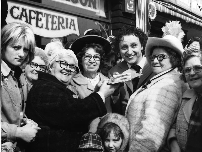 A large crowd of fans and a large jam butty (freshly caught in the Irish Sea) greeted comedian Ken Dodd when he arrived in Blackpool. Ken was here for the official opening of a new cafe, the Chuck Wagon in Deansgate, owned by Gerard Naprous and his partner Tina
22nd March 1974