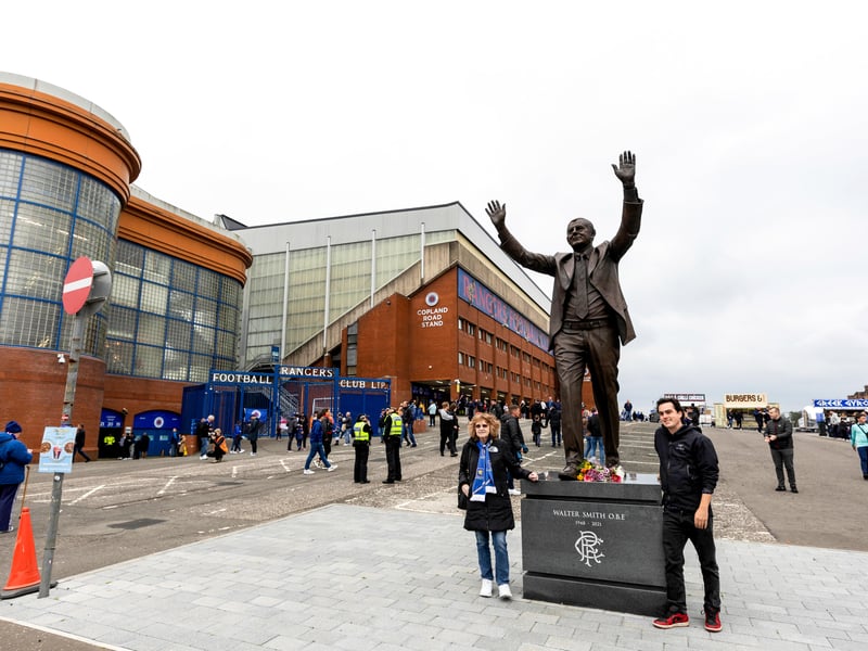 Rangers fans pose for pictures beside the Walter Smith statue outside Ibrox Stadium.