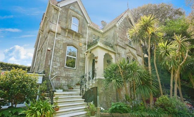 The listing says: "Wrought iron gates lead to a sizeable front driveway and parking area at the front aspect, with the property sitting on sizeable and beautifully maintained grounds."