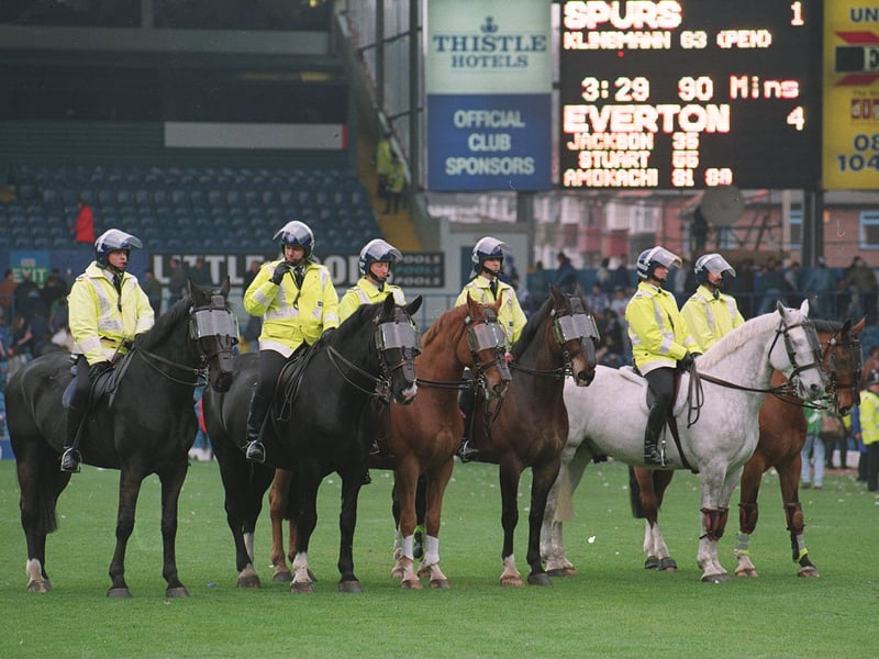 Mounted police clear the pitch after an invasion by Tottenham Hotspur supporters during an FA Cup semi-final in the mid-1990s. The old scoreboard can be seen in the background.