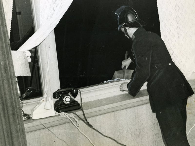 A fireman helps to clear up the Mayoress's room at Blackpool Town Hall after an IRA bomb attack