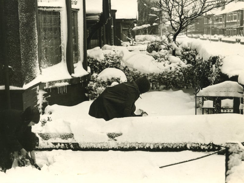 The scene in a Blackpool street following a heavy fall of snow in 1940. Clearing the snow was everyone's job before they could get out