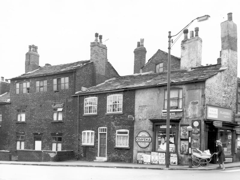 The junction of Amberley Road and Tong Road in May 1965. Number 77 Amberley Road can be seen on the left, a three storey building. Moving right, number 79, then number 99 Tong Road, a sweet and tobacco shop and newsagents, business of E.H. and D. Brunton. Posters advertise various magazines and newspapers including an article on Face Lifts for Men in Reveille.