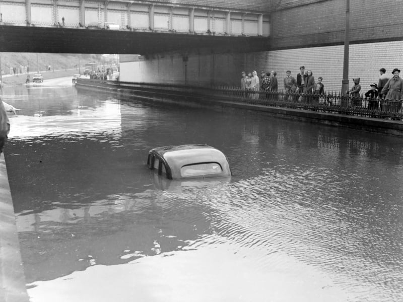 A terrific thunderstorm and downpour of rain caused flooding in several areas of Blackpool in 1958. The depth of the water under the railway bridge at Devonshire Road is indicated by the stranded car