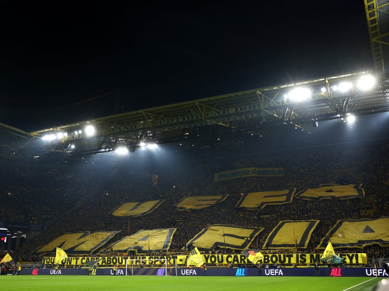 Borussia Dortmund unveil a banner prior to kick-off which reads '"UEFA you don't care about the sport - all you care about is money'.