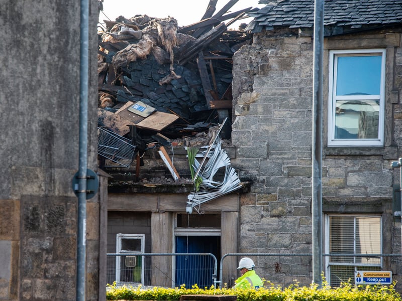 An emergency worker visits the Kellie Place property after the explosion on Sunday. Engineers from gas distribution network Scottish Gas Networks are among those at the scene