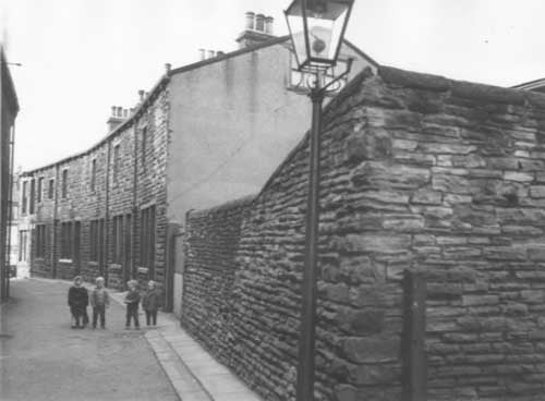 New Scarbro Road, on the junction with Stanningley Road is just visible. The shop at the corner is 180 Stanningley Road, Proctors grocers. Four children are facing the photographer. Pictured in April 1964.