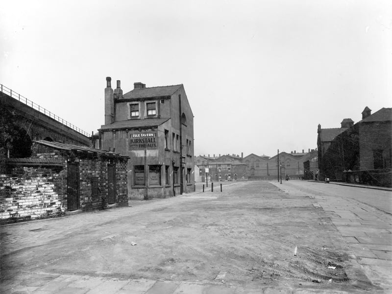 This view is taken from the partially demolished Front Walk and the vacant land that was Czar Street. On the left hand side of Front Walk, at number 27, is The Isle Tavern public house, a three storey building which was owned by Kirkstall Brewery at that time and is advertising their "Fine Ales". Pictured in May 1936.