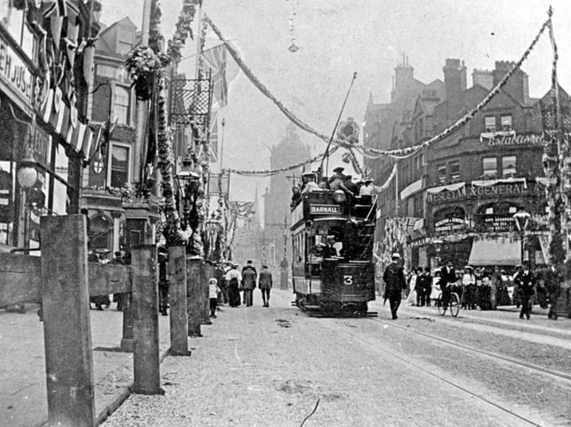 An electric double-decker tram on Pinstone Street. Sheffield city centre, decorated for the visit by King Edward VII in July 1905