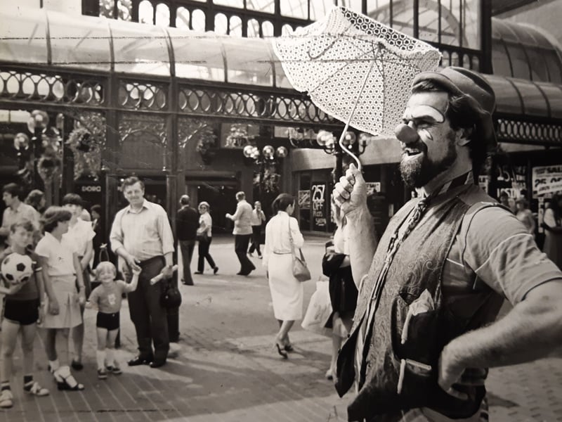 This is 'Albert the Idiot' alias Ian Scott Owens who was entertaining crowds with an endearing mixture of clown, puppeteer, balloon moulder and magician. He was the first in a seven programme of entertainers hired by Houndshill to encourage business in July 1982