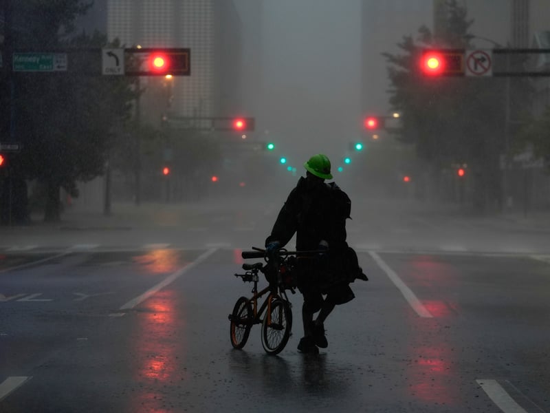 Ron Rook, who said he was looking for people in need of help or debris to clear, walks through windy and rainy conditions on a deserted street in downtown Tampa, Florida.