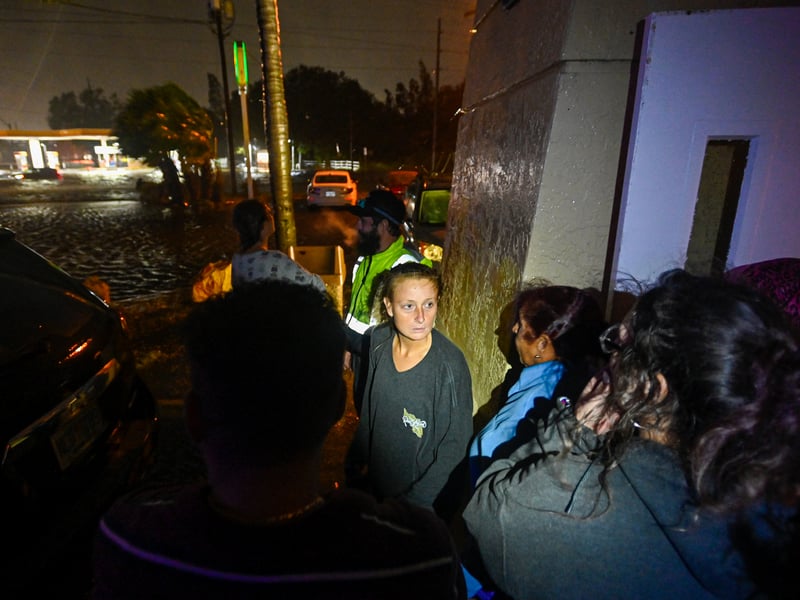 People watch water-flooded streets after Hurricane Milton made landfall in Brandon, Florida.