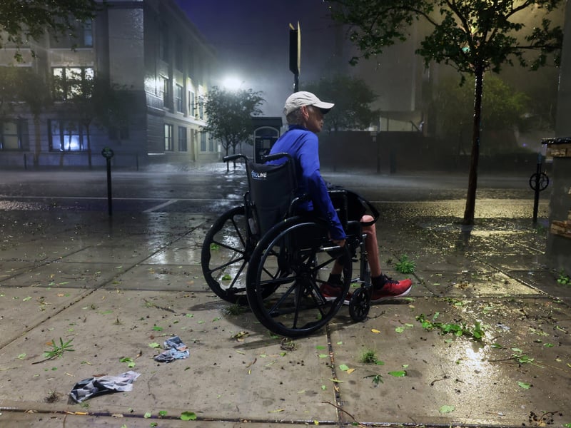 A woman in a wheelchair makes her way along a downtown sidewalk in Tampa, Florida.