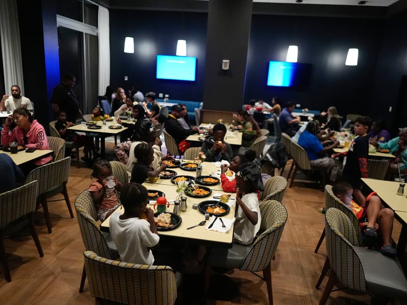 Off-duty staff members and their families, who were invited to come stay with them in hotel rooms as they worked through Hurricane Milton, eat dinner as the storm makes landfall on Florida's Gulf Coast, at Hyatt Place Tampa Downtown Hotel in Tampa.
