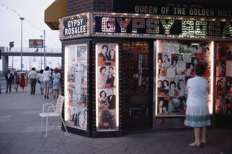 A woman ponders the illuminated front of Gipsy Rosalee's fortune telling service i9n 1983. The sign says that Gipsy Rosalee was the queen of the Golden Mile and the photographs display famous customers including Jimmy Tarbuck and Eddie Large