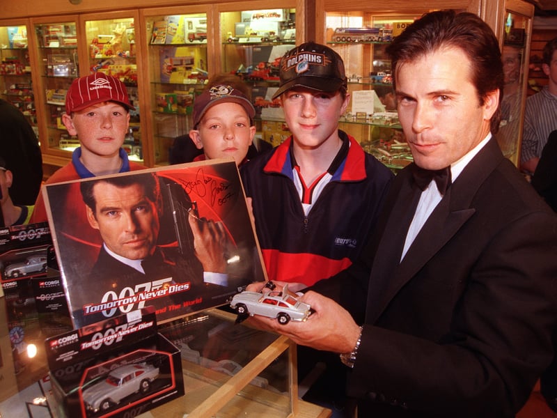 James Bond stunt double Douglas James signs autographs to promote the Corgi James Bond car models, on sale at Collector's Choice, The Lane, Meadowhall. Seen getting their picture autographed are Andrew Robinson, David Robinson, and Edward Walsh