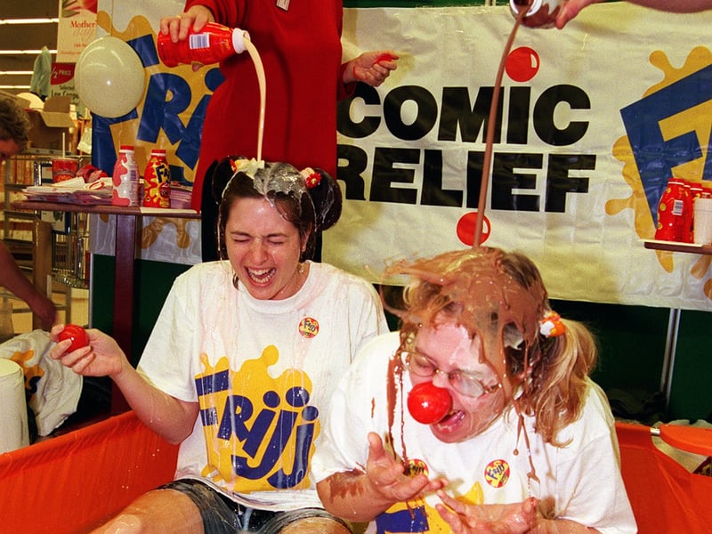 Charlotte Aust and Lynn Blore get covered in Frijj at Meadowhall as part of the Comic Relief fundraising