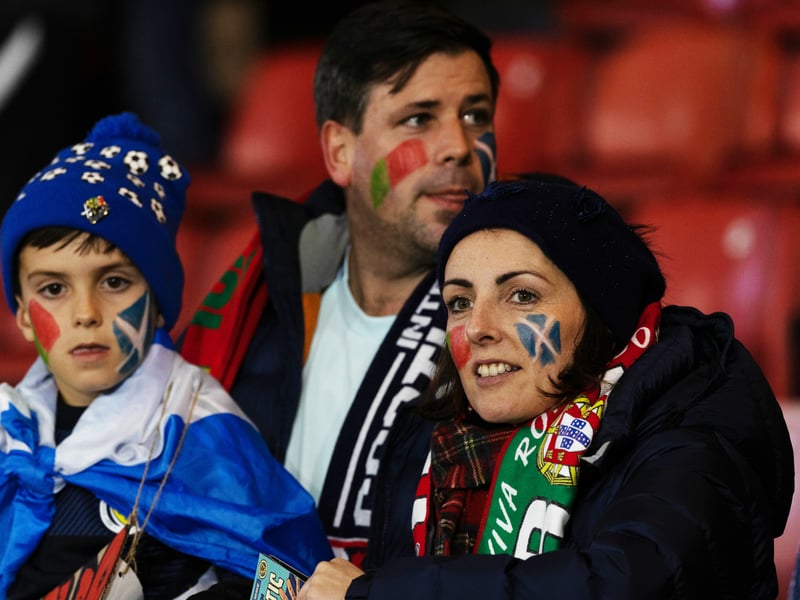 Scotland fans paint their faces with each nations flag ahead of the game.