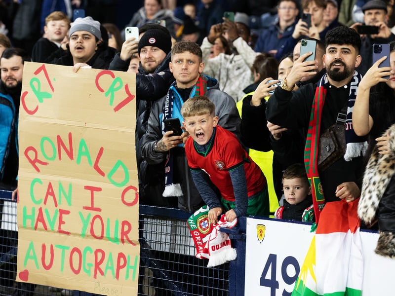 A young fan with a Cristiano Ronaldo sign asking for his authograph.