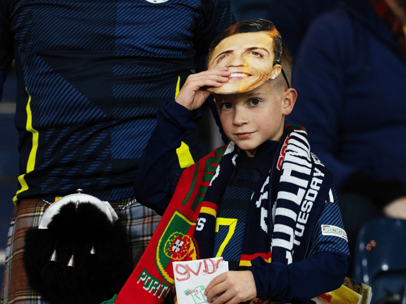 A young Scotland fan peers out from under his Cristiano Ronaldo mask.