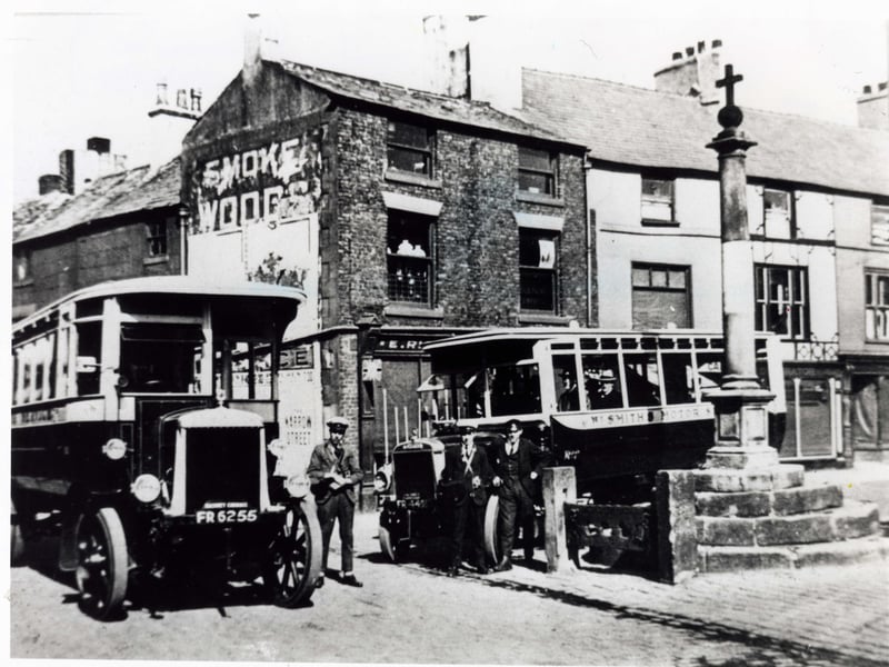 Early public transport picking up passengers in the Market Place at the corner of Blackpool Old Road. The stocks visible in this photograph were to be damaged many times in the years to come by buses turning into the square. They have been repaired and replaced so many times that neither of the stone pillars is the original medieval stonework