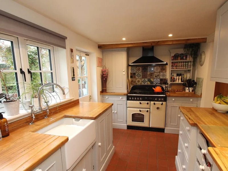 The listing says: "The rear garden is a standout feature of the property, starting with a patio beneath a striking oak-framed, glazed pergola. You'll also find an outdoor light and water tap here."