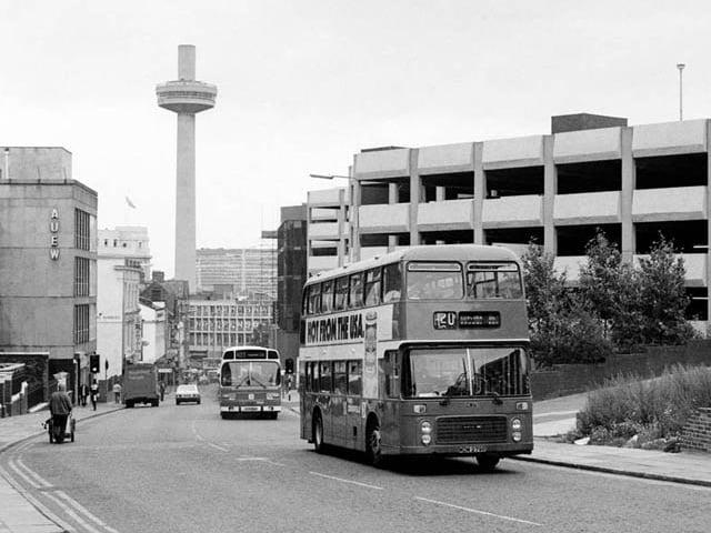 A bus travels past Mount Pleasant car park and St Johns Tower, 1985.