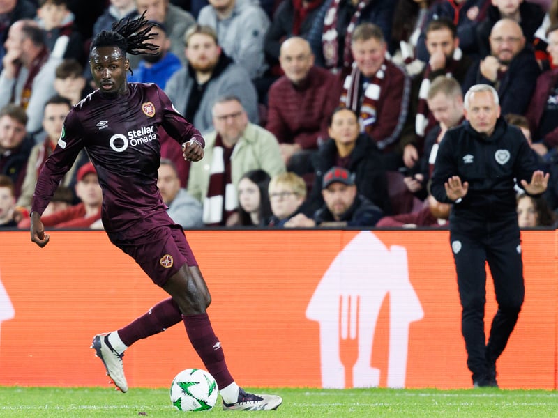 Hearts fans and new head coach Neil Critchley watch on as Malachi Boateng controls the ball.