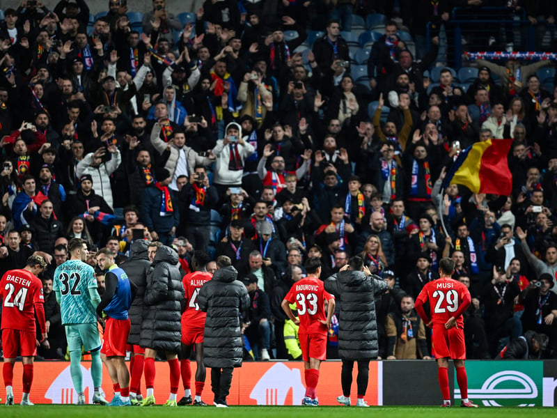 The FCSB players applaud their supporters at full time.