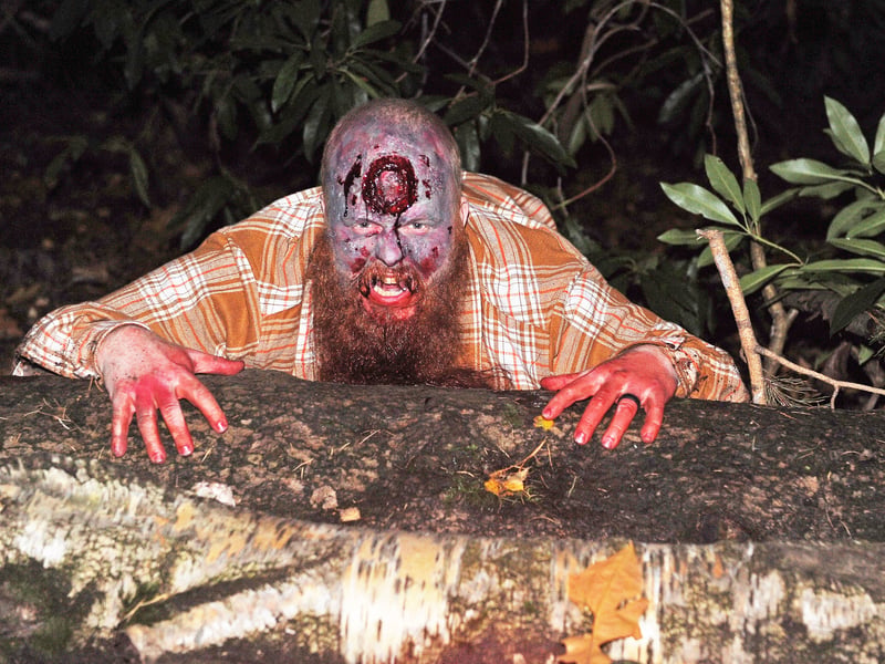 Jamie Emsley crawls out of the wood to meet the guests.