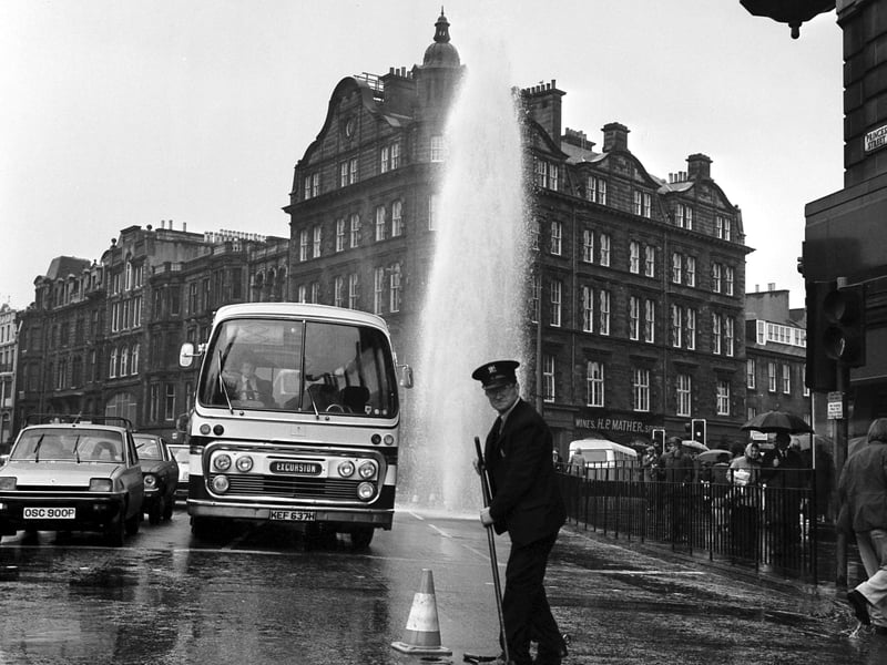A Water Board worker turning off the jet from a burst water main at the west end of Princes Street Edinburgh in May 1977.