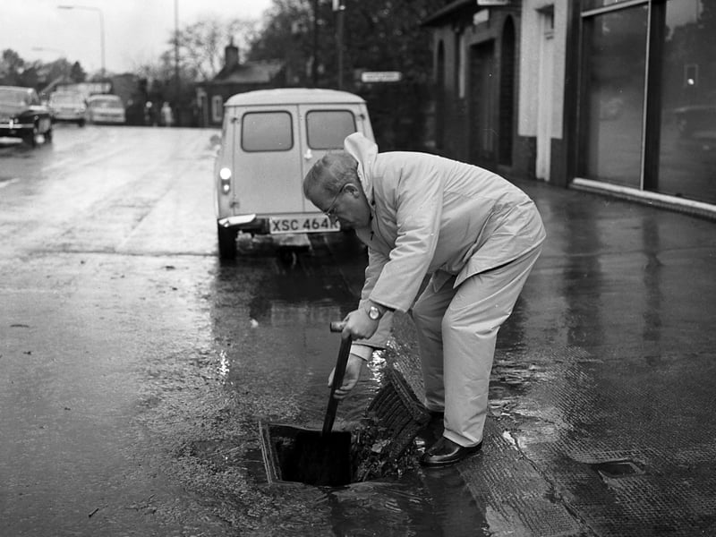 A council worker clears the drains after flooding in Edinburgh in October 1977.