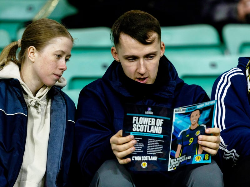 Two Scotland fans check out the matchday programme ahead of the play-off clash.