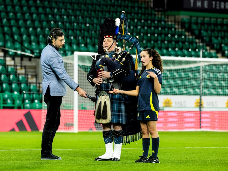 A piper plays A Flower of Scotland alongside a young sign language interpreter.
