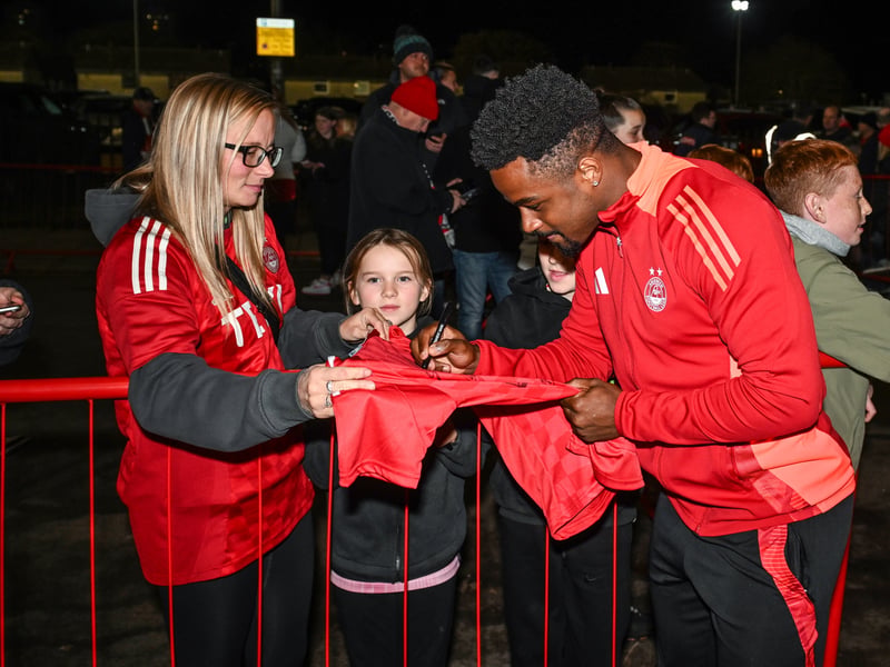 Fans get their Aberdeen merchandise signed by Duk ahead of the game.