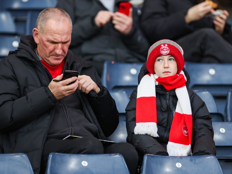 Two Aberdeen fans get ready for the game at Hampden Park.