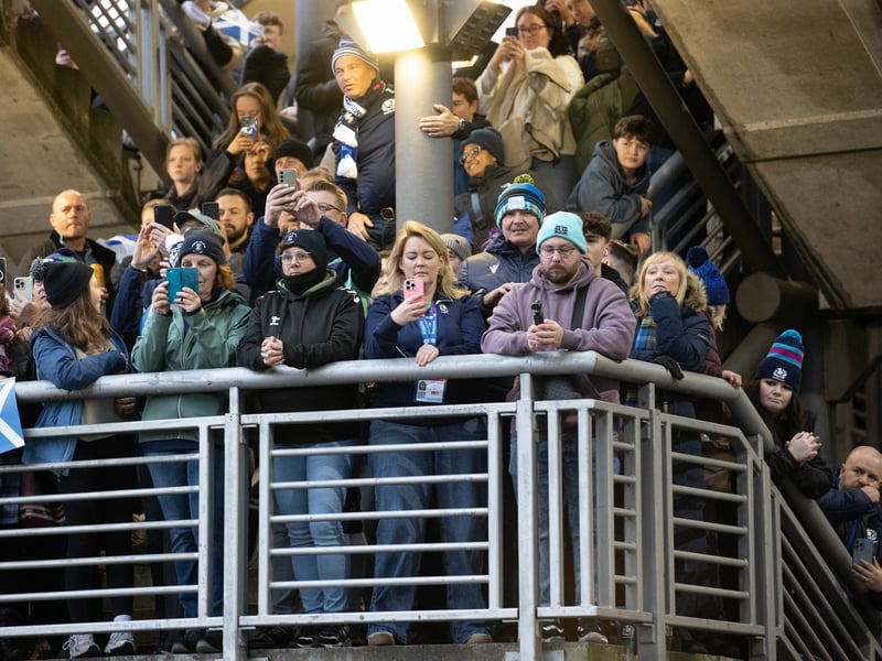 Scotland fans await the team bus from the stairs.