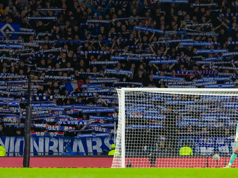 Rangers fans raise their scarves behind the Motherwell goal.