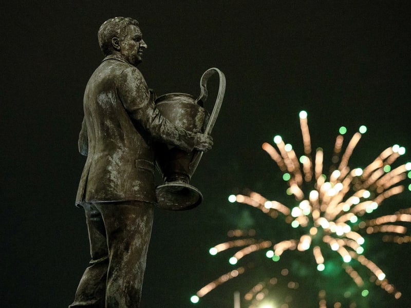 Fireworks go off in the background of the Jock Stein statue outside the stadium.