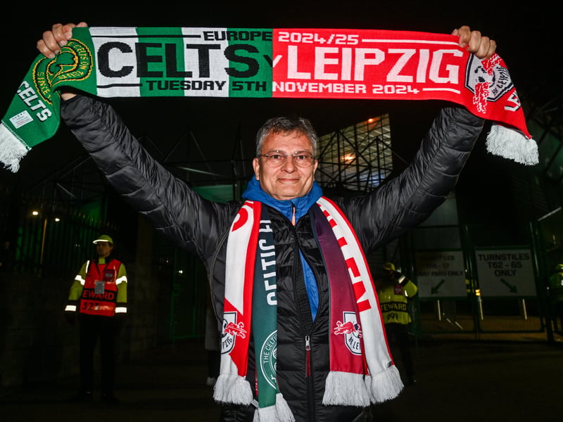 A Leipzig supporter waves his flag above his head prior to the game kicking off.