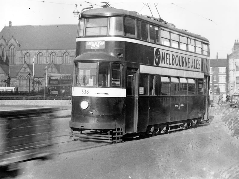 Tram 533 at Woodpecker Junction travelling route 22 heading into Leeds, St Patricks Church can be seen on left. It has been noted on the photograph that view taken in connection with burst water main. Pictured in October 1954.