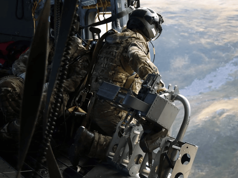 Aircrewman working inside of a Merlin Mk4 helicopter during mountain flying training.